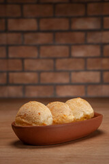 Cheese breads on serving dish on bricks wall background.