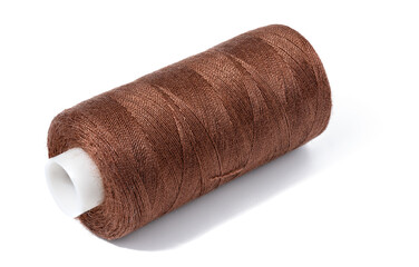 Spool of brown cotton thread for needlework and sewing on a white isolated background