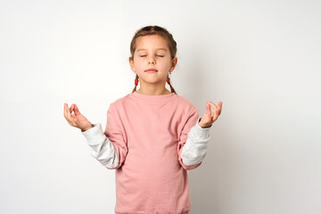 Cute girl meditating with closed eyes, white background