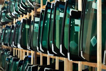 Lots of windshields for different cars on service station shelves ready to install or replace...