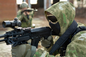 A group of soldiers in a war zone playing airsoft.