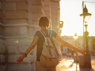 summer female solo trip to Europe, happy young woman walking on european street at sunset time. Vienna, Austria