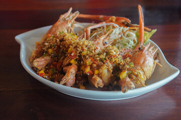 Stir Fried Prawn with Chili and Salt Add chili, salt, seasoning, shredded cabbage Placed in a white ceramic plate, placed on the table.