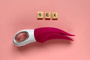Sex toy. Pink vibrator on a pink background. lettering SEX. Useful for adult, sex shop. Top view