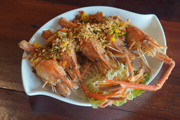 Top view Stir Fried Five Prawns with Chili and Salt Add chili, salt, seasoning, shredded cabbage Placed in a white ceramic plate, placed on the table.