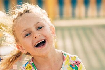 sunny summer day excited happy smiling face portrait child girl in yellow dress play on colored...