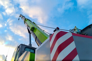 The boom of a tower truck crane against a blue sky.