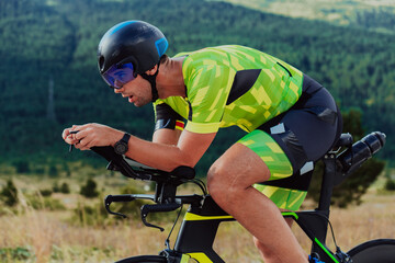 Close up photo of an active triathlete in sportswear and with a protective helmet riding a bicycle. Selective focus