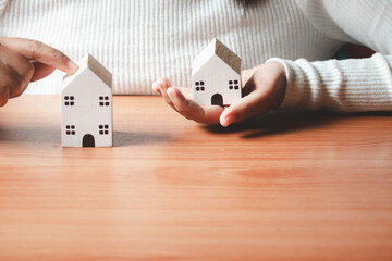 Woman's hand with a small house in hand, vintage style.