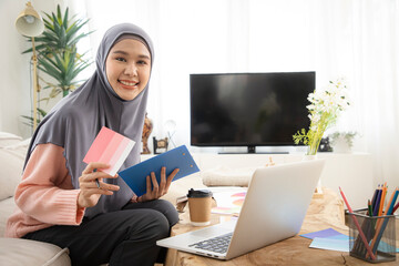 Portrait of Asian muslim woman graphic designer working on new project with color swatches. Creative Asian lady working on interior for their new house. Valentine day concept