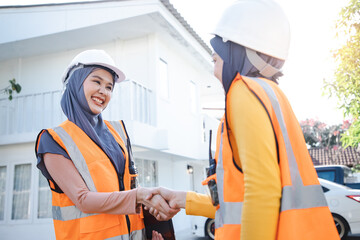 Successful projects. Muslim woman wearing a protective helmet standing in front of modern house, Agreement with new projects. Industry and engineer concept.