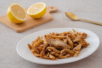 Crispy fried small fish on white plate