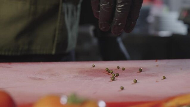 Slow-motion video of pouring marinated red pepper onto a board. Spectacular video of a chef working in a restaurant kitchen. High quality 4k footage