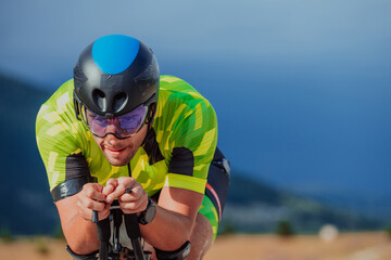 Close up photo of an active triathlete in sportswear and with a protective helmet riding a bicycle....