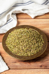 Dried thyme leaves. Thyme spice in a bowl on a wooden background. Dry spice concept. Close up