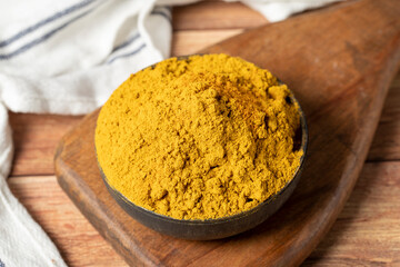 Curry Masala Powder. Turmeric powder or curry powder spice in a bowl on wooden background. İndian...