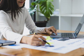 Accountant working with laptop and auditing in office. Woman analyzing business reports and...