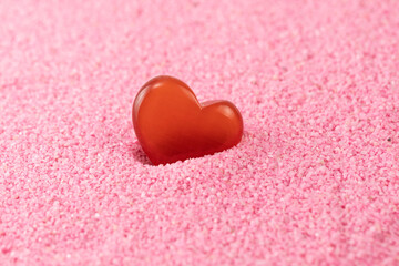 Red heart-shaped rocks on a pink beach