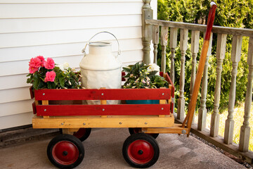 Red Wagon With White Milk Can and Flowers in it on Porch