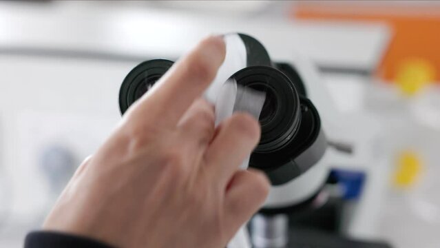 scientist cleaning microscope diopter eyepieces