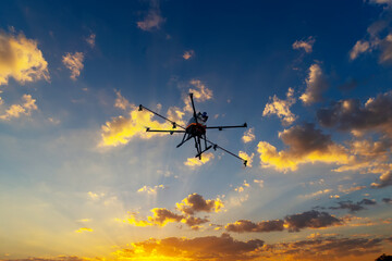 Fototapeta na wymiar Drone flying in the air. Sunrise background.