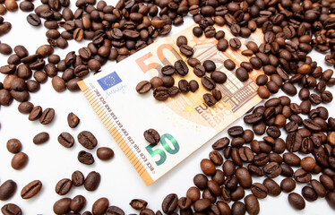 Coffee grains with fifty Euro on a white background.