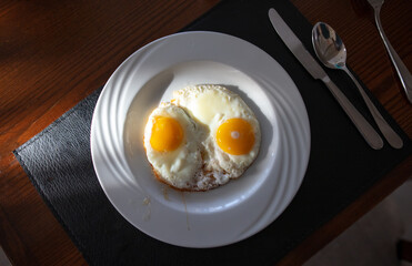 Fried eggs in a plate on a table in a cafe.