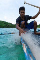 young filipino fisherman leaving his fishing net at sea, real people, lifestyle. philippines islands.