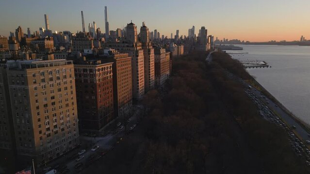 sunset flying backwards north over Riverside Park revealing monument on the upper west side of NYC