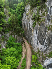 Aerial drone panorama above a narrow canyon sided by vertical, abrupt, steep cliffs. The gorges are...