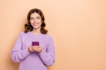 Fototapeta premium Portrait of cheerful girl wavy hairstyle dressed violet pullover chatting phone look empty space isolated on pastel color background