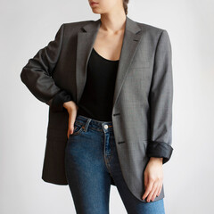 Woman wearing oversized blazer and blue jeans isolated on white background