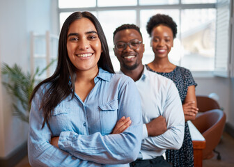 Trio of diverse business people lined up for portrait, focus on Indian woman