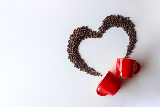 Coffee lover. Top view of red  cup and Coffee beans arranged in a beautiful heart shape on white background.  Festive card for Valentines Day. top view. flat lay. 3D illustration