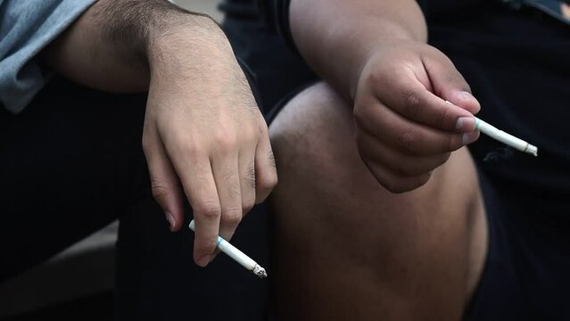 Amigos fumando juntos en un plano detalle a los cigarrillos.