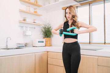 Fototapeta na wymiar motivated pretty woman pushing exercise tool in kitchen. gorgeous exerciser exercising exercise tool for muscle indoors. beautiful woman training home fitness holding equipment for healthy arm muscle