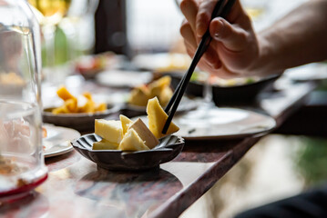 hand take cheese cube on table in restaurant