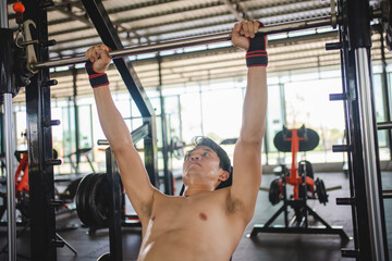 Asian man exercising with a barbell in the fitness