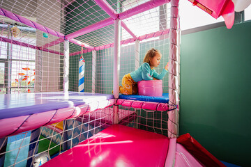 Obraz na płótnie Canvas Happy girl playing at indoor play center playground.