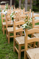 Wooden chairs with flowers wedding ceremony