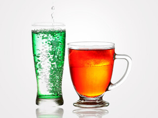 A glass of Splashing soda and bubbles and a glass of cola. Soft drink or Refreshment