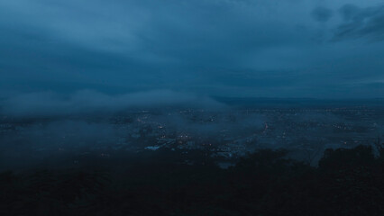 The mist drifted over the city in the evening before it fade away. Fog over the city, city in fog.