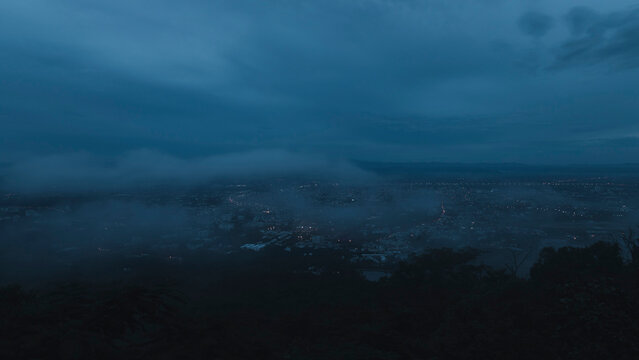 The mist drifted over the city in the evening before it fade away. Fog over the city, city in fog. - Powered by Adobe