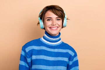 Photo of positive satisfied good mood smile use wireless blue sony headphones listen music modern...
