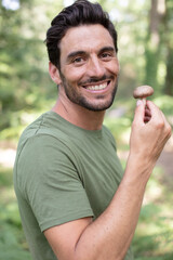 smiling man holds a mushroom