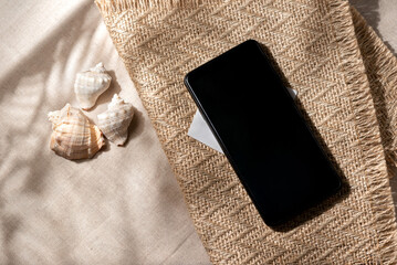 Minimalist aesthetic neutral summer vacation texture. Closeup view of sea shell on a beige textile background.