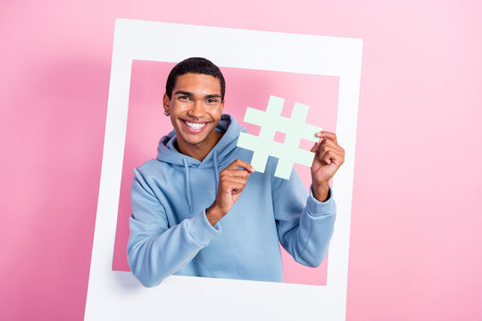 Photo of popular instagram blogger party remember cadre paper frame funny man hold hashtag pin trendy word isolated on pink color background