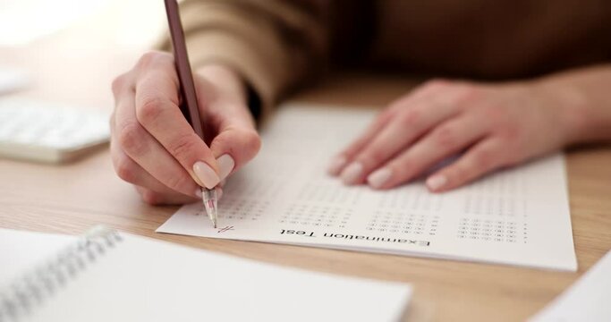 Woman hand holds pencil and marks answers to test