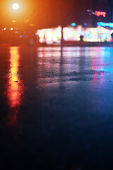 Urban street wet asphalt reflecting colorful lights