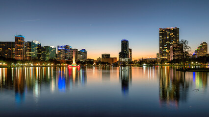 Orlando city skyline at sunset in Lake Eola Park with fountain, Florida, USA
